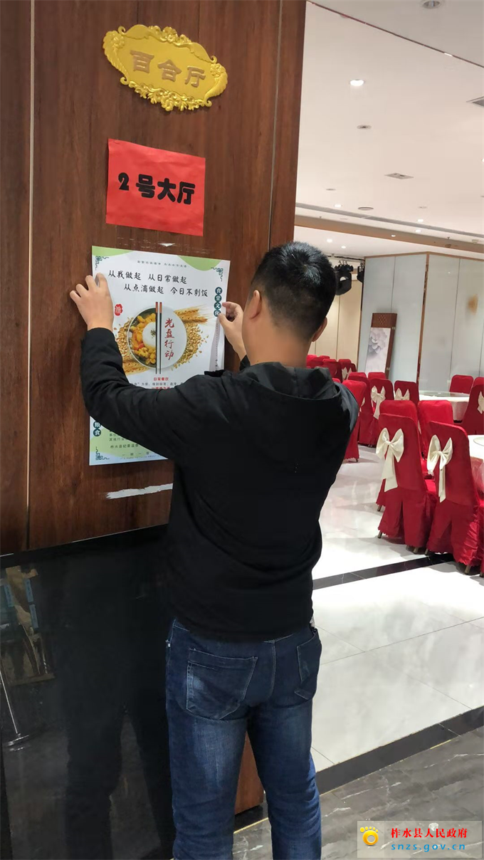 工作人员张贴文明用餐宣传画.jpg 工作人员张贴文明用餐宣传画.jpg